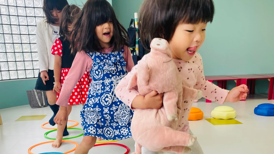 ぬいぐるみを抱えて自由遊びを楽しむ幼児たち
