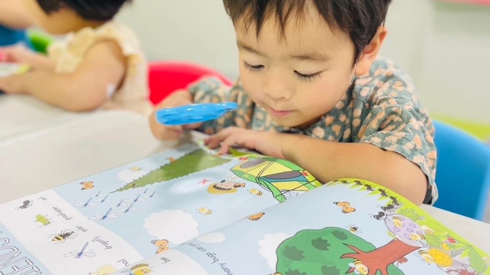 絵本を見ながらテーマ学習に取り組むプレスクールの子ども