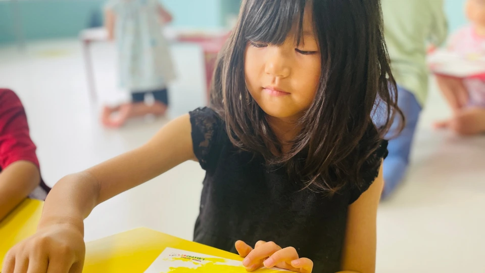 英語を使いながら制作活動に集中する幼児
