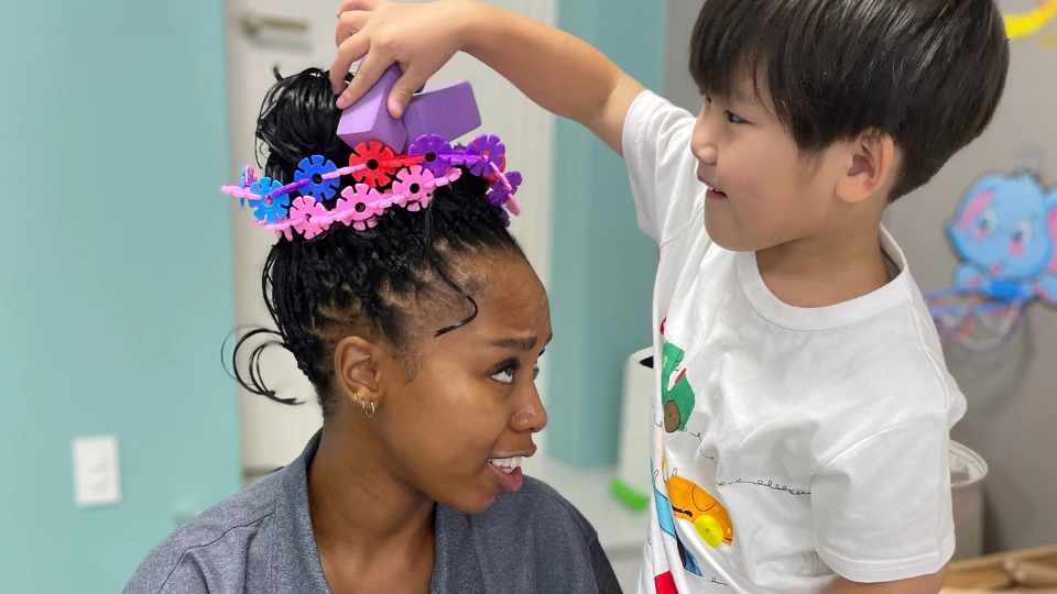 ストーリータイムで講師が子どもに花の冠をかぶせる様子